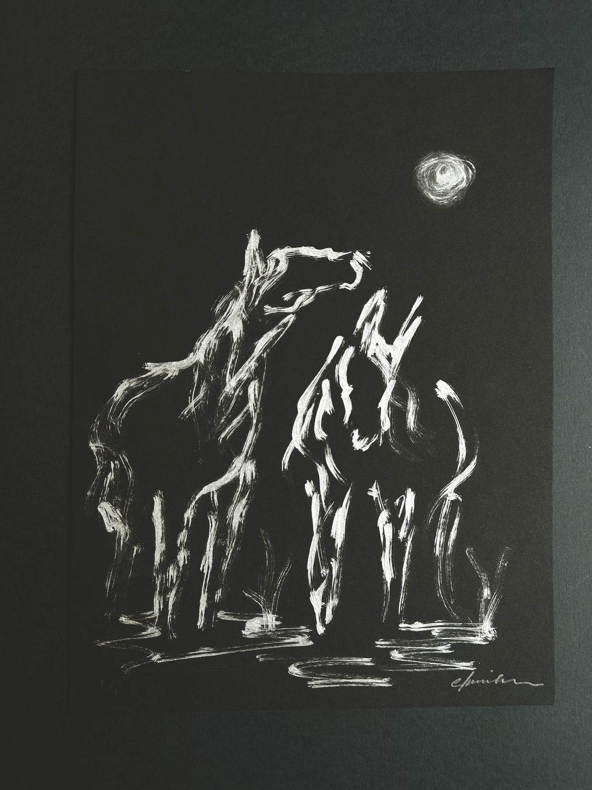 Close-up of the silver acrylic horses and moon on black paper