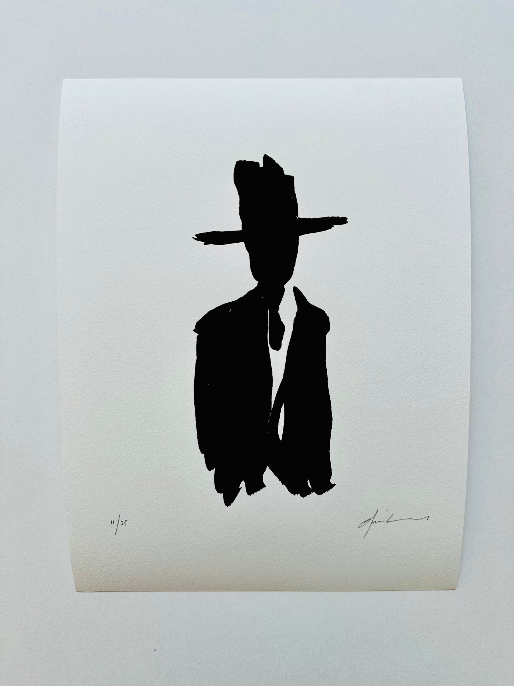 Black silhouette of a man in a cowboy hat, print on white paper
